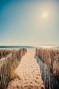 een hek op het strand met de oceaan op de achtergrond bij Toison D'or in Saint-Tropez