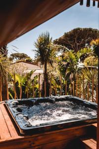 a hot tub sitting on a deck with palm trees at Toison D'or in Saint-Tropez