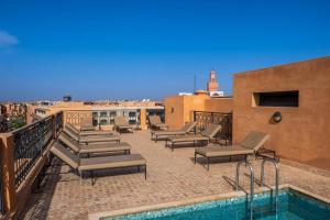 een patio met ligstoelen en een zwembad in een gebouw bij TOP APPARTEMENT GUELIZ in Marrakesh