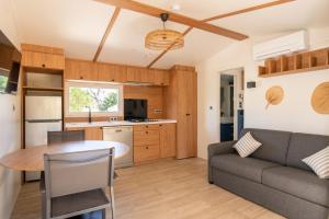 eine Küche und ein Wohnzimmer mit einem Sofa und einem Tisch in der Unterkunft Toison D'or in Saint-Tropez