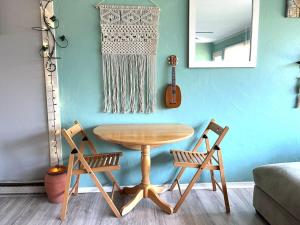 uma mesa e cadeiras numa sala de estar com uma guitarra em Sweet Sunny Summit House em Greensboro