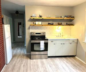 a kitchen with a stove and a sink at Sweet Sunny Summit House in Greensboro