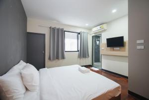 Yan Nawa的住宿－GO INN Silom - BTS Saint Louis โกอินน์ สีลม - สถานีรถไฟฟ้าเซนต์หลุยส์，卧室配有白色的床和电视。
