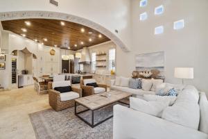 a living room with white furniture and a kitchen at License To Chill in Seagrove Beach