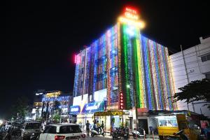 a large building with colorful lights on it at night at HOTEL SLN COMFORTS in Tumkūr