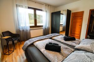 een slaapkamer met een bed, een stoel en een raam bij Exklusive Moselidylle: Fewo mit traumhaftem Staustufenblick, Netflix, Terrasse in Neef