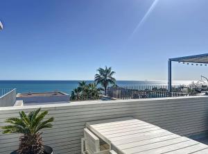 a view of the ocean from a patio with a table at Duplex vistas mar con piscina in Sant Pere de Ribes