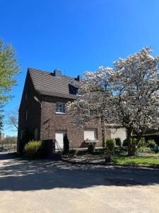 una gran casa de ladrillo con un árbol delante en Haus Neuss-1.OG, en Neuss