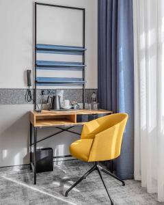 a yellow chair and a desk in a room at IQ Hotel in Kyiv