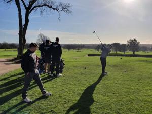 un groupe de personnes jouant au golf sur un terrain dans l'établissement LONDON EXPERIENCE, à Eltham