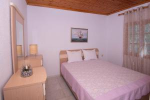 a bedroom with a bed and a dresser and a window at Casa Chrysi in Mesimvría