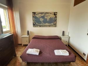 ファルコナーラ・マリッティマにあるCleo Magnoliaのベッドルーム1室(ベッド1台、タオル2枚付)