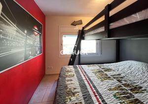 een slaapkamer met een stapelbed en een rode muur bij VENETO 3-1 in Platja  d'Aro