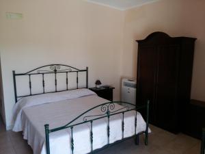a bedroom with a bed and a wooden dresser at La Mortella Agriturismo in Rotondella