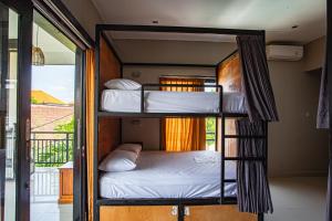 two bunk beds in a room with a balcony at What The Duck Backpackers in Canggu