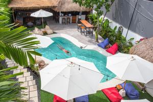 an overhead view of a swimming pool with umbrellas at What The Duck Backpackers in Canggu