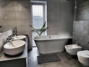 łazienka z 2 umywalkami, wanną i toaletą w obiekcie Luxury Home in Vilnius w Wilnie