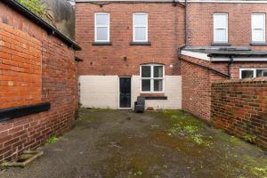 an alley between two brick buildings with a garage at Spacious and Stylish House - Sleeps 12 in Sheffield