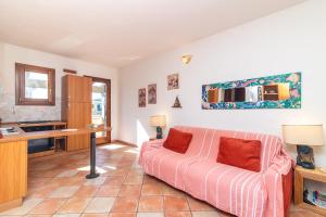 een woonkamer met een bank en een bureau bij Appartamento I Lecci in San Teodoro +12 foto's