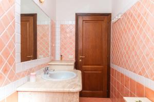 een badkamer met een wastafel en een spiegel bij Appartamento I Lecci in San Teodoro
