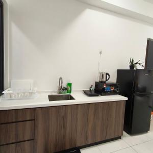 a kitchen with a sink and a black refrigerator at New Urban Suite Majestics 3BR Homestay at Georgetown BY URBAN STAYCATION HENG LOD in Jelutong