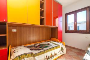 een slaapkamer met een bed met gele en rode kasten bij Appartamento I Lecci in San Teodoro