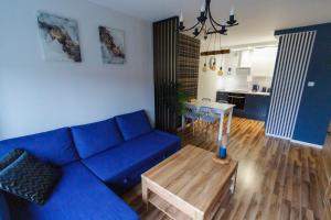 een woonkamer met een blauwe bank en een tafel bij South House in Włocławek