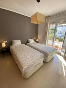 1 Schlafzimmer mit 2 Betten und einem großen Fenster in der Unterkunft Rez-de-chaussée bord de piscine in Los Tomases