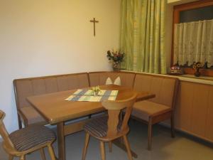 een eettafel en stoelen met een kruis aan de muur bij Ferienwohnung Sporer in Hippach