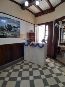 a lobby with a checkered floor and a counter at La Casona-Hotel in Mar del Plata