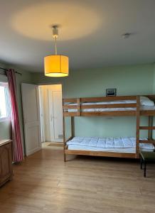 a bedroom with two bunk beds and a light at VILLA LES MOUETTES - Maison 8 couchages in Quiberville