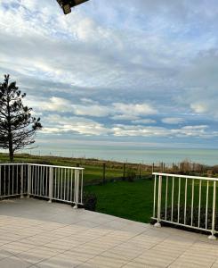 a view of the ocean from a porch with a fence at VILLA LES MOUETTES - Maison 8 couchages in Quiberville
