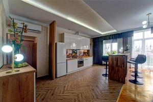 a kitchen with a refrigerator and two stools in a room at APARTAMENTY in Przemyśl