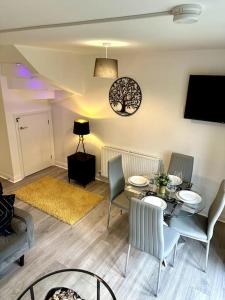a living room with a table and chairs and a television at Birmingham Bliss Central 5-Bed Escape in Birmingham