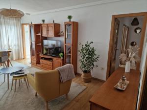 a living room with a television and a dining room at Lovely Balaídos in Vigo