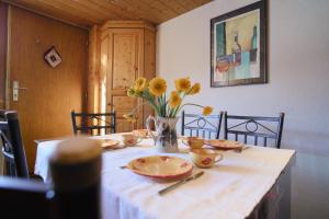 un tavolo con piatti e un vaso di fiori sopra di Historisches Walserhaus near Arosa a Peist