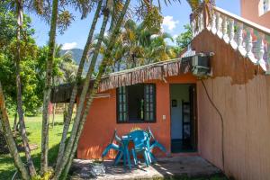 uma casa com duas cadeiras azuis fora dela em Recanto da Rose Guesthouse em Caraguatatuba