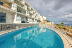 una grande piscina accanto a un edificio di Lovely home with beautiful view with communal pool by 360 Estates a Taʼ Bullara