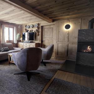 a living room with a chair and a fireplace at Historisches Walserhaus near Arosa in Peist