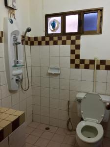 Buakao Inn في تونغسالا: حمام مع مرحاض ونافذة