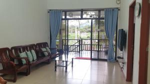 a living room with chairs and a large window at Bonsai Villa @ Mesilou 盆栽小苑 in Kampong Kundassan