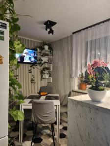 a kitchen with a table and a dining room with plants at Nad jeziorem u Beaty in Jezierzany