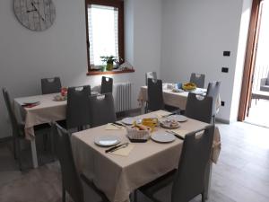 a dining room with tables and chairs with food on them at B&B Vivi l'Attimo in Campodenno