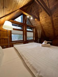 a bedroom with a large white bed in a cabin at Kapteinis&Grants in Engure