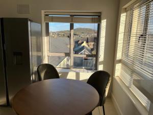 a table and chairs in a room with a large window at 2 Bedroom apartment Park Lodge in Enniscorthy