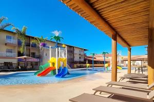 um parque infantil num resort com cadeiras e uma piscina em Ondas Praia Resort em Porto Seguro em Porto Seguro