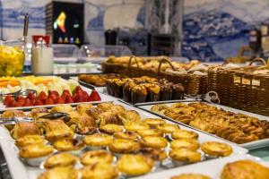 um buffet repleto de diferentes tipos de produtos de pastelaria e frutas em Hotel Columbano em Peso da Régua