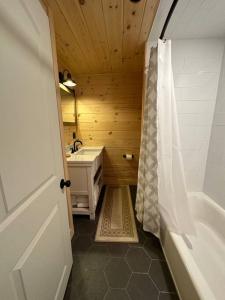baño pequeño con ducha y lavamanos en Redwood - Lakeside Cabin, en Bradford