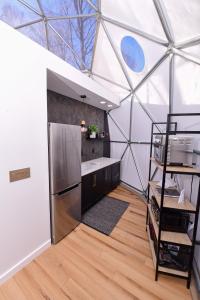 cocina en una cúpula de cristal con nevera en Tranquility Luxe Dome - Hot Tub & Luxury Amenities en Swiss