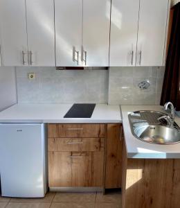 a kitchen with white cabinets and a sink at A&D Apartments in Porto Rafti